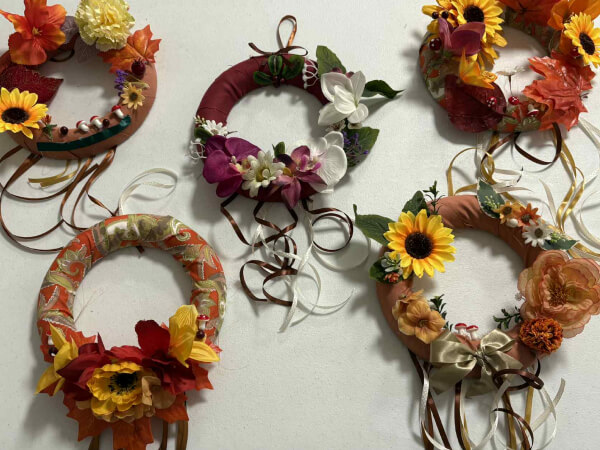Pięć wianków, które można powiesić na drzwiach. Wianki mają na sobie elementy florystyczne.