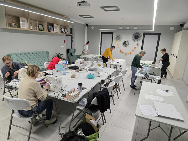 Kurs szycia dla dorosłych. Stoliki są tak pozostawione by każda z uczestniczek miała miejsce do swobodnej pracy.